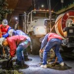 Street workers cleaning drainage at night with machinery under a bridge. - Photo by JESUS ADRIÁN SAAVEDRA on Pexels