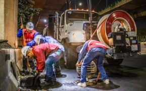 Street workers cleaning drainage at night with machinery under a bridge. - Photo by JESUS ADRIÁN SAAVEDRA on Pexels