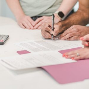 Team collaboration on paperwork with calculator and documents on a white table. - Photo by RDNE Stock project on Pexels