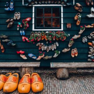 A vibrant display of colorful clogs on a traditional house wall showcases Dutch culture and design. - Photo by Helena Jankovičová Kováčová on Pexels