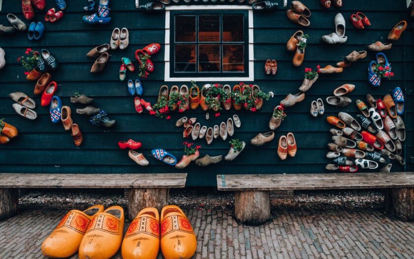 A vibrant display of colorful clogs on a traditional house wall showcases Dutch culture and design. - Photo by Helena Jankovičová Kováčová on Pexels