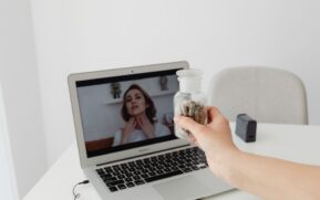 Person holding supplements during a virtual consultation with a doctor on a laptop. - Photo by www.kaboompics.com on Pexels