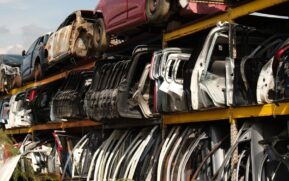 Rows of car doors stacked in a junkyard under a clear sky. - Photo by Aziz Er on Pexels
