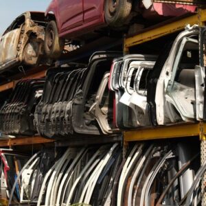 Rows of car doors stacked in a junkyard under a clear sky. - Photo by Aziz Er on Pexels