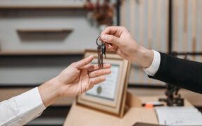 Detailed view of hands exchanging keys in a professional office environment, symbolizing real estate or business transactions. - Photo by Pavel Danilyuk on Pexels