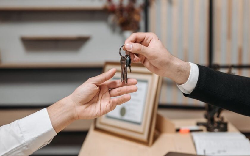 Detailed view of hands exchanging keys in a professional office environment, symbolizing real estate or business transactions. - Photo by Pavel Danilyuk on Pexels