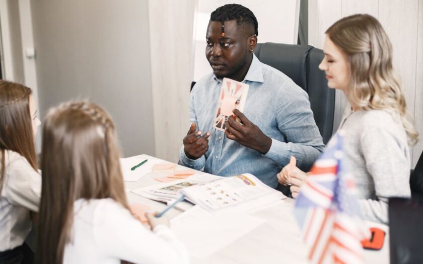 Teacher guiding diverse students in an English language lesson with a British flag card. - Photo by Gustavo Fring on Pexels