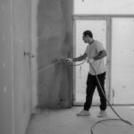 A worker paints an interior wall with a spray gun during a renovation project. - Photo by Tima Miroshnichenko on Pexels
